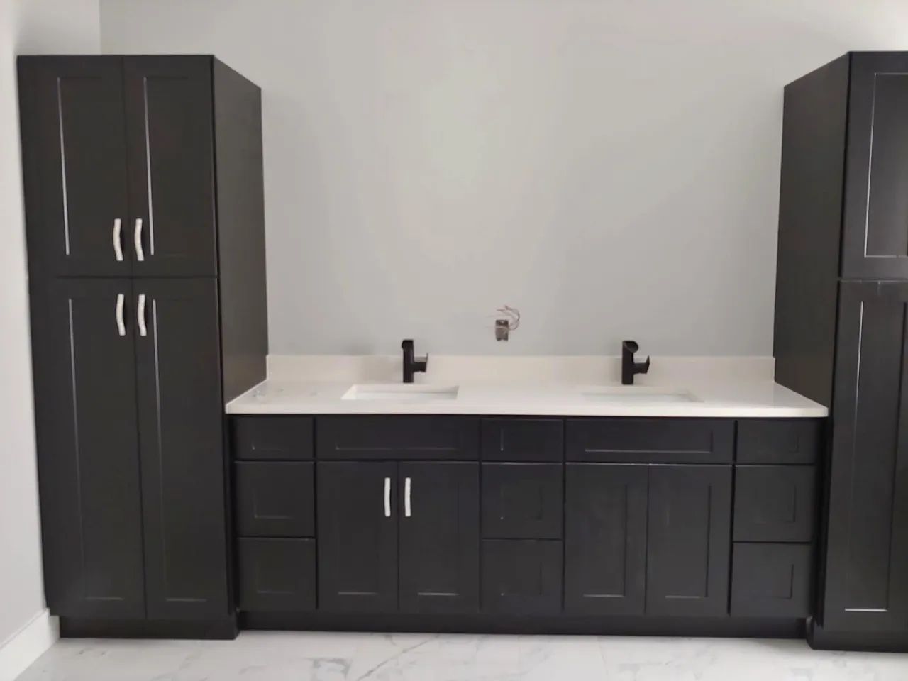Dark double vanity with linen towers